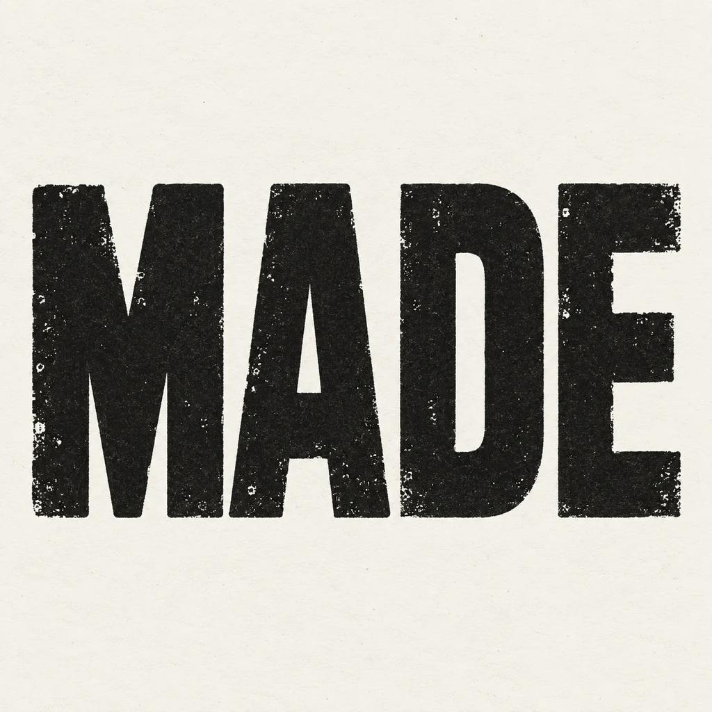 MADE in four near-black stamped-ink capitals on warm off-white paper, with small ink skips and complete counters